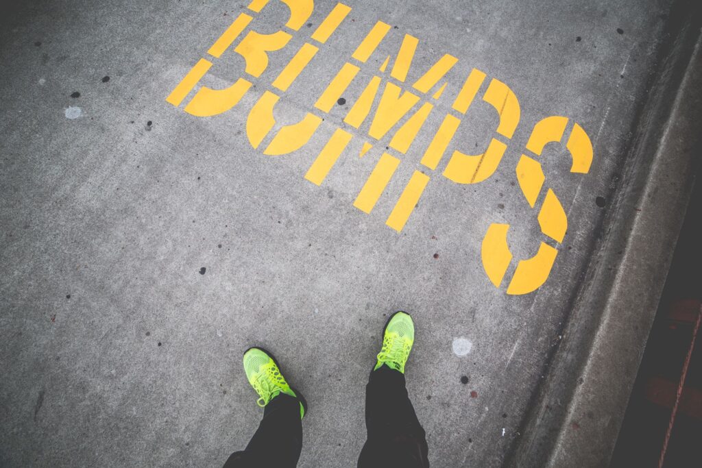 Person in yellow shoes looking at word BUMPS in yellow on street