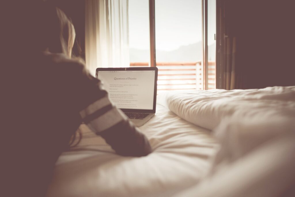 Lady reading a computer on a bed