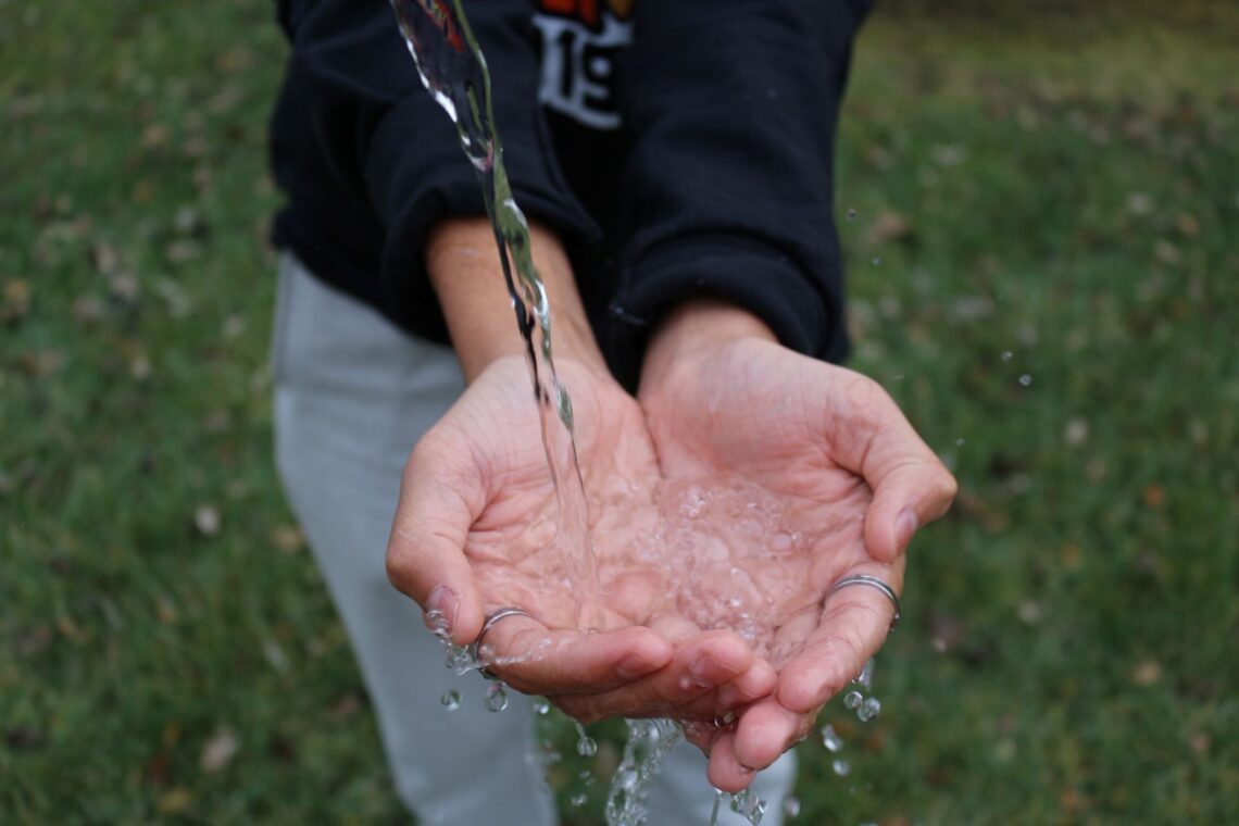 boy catching a stream of water in his hands