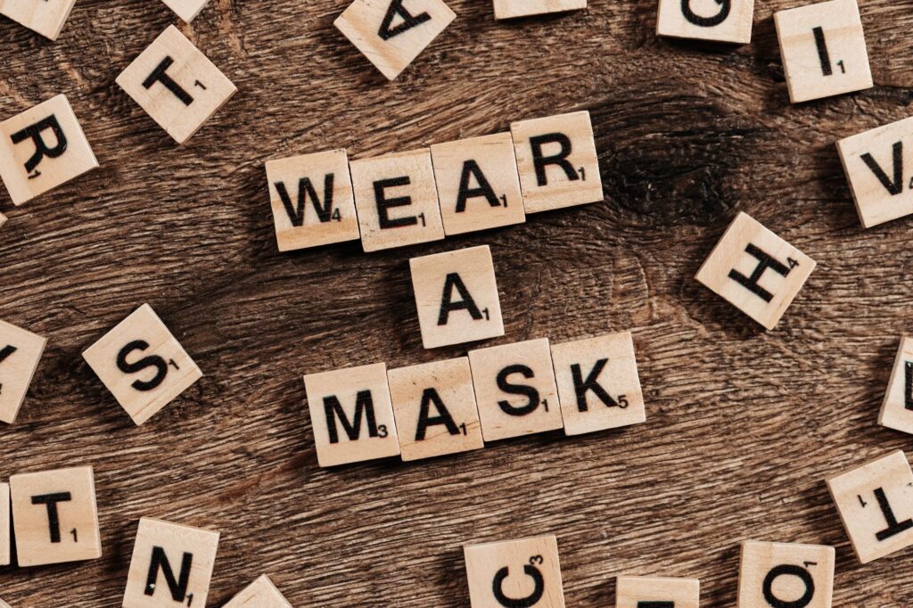 The words WEAR A MASK spelled out using scrabble tiles