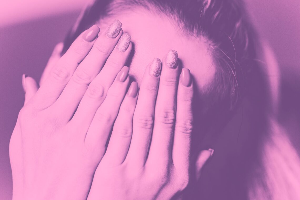 duotone image of woman hiding her face with her hands