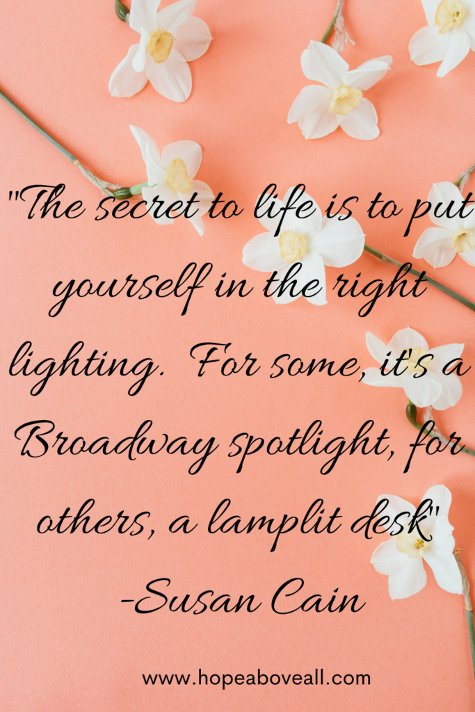 A peach background picture with white flowers with the quote:
 "The secret to life is to put yourself in the right lighting.  For some, it's a Broadway spotlight, for others, a lamplit desk." - Susan Cain