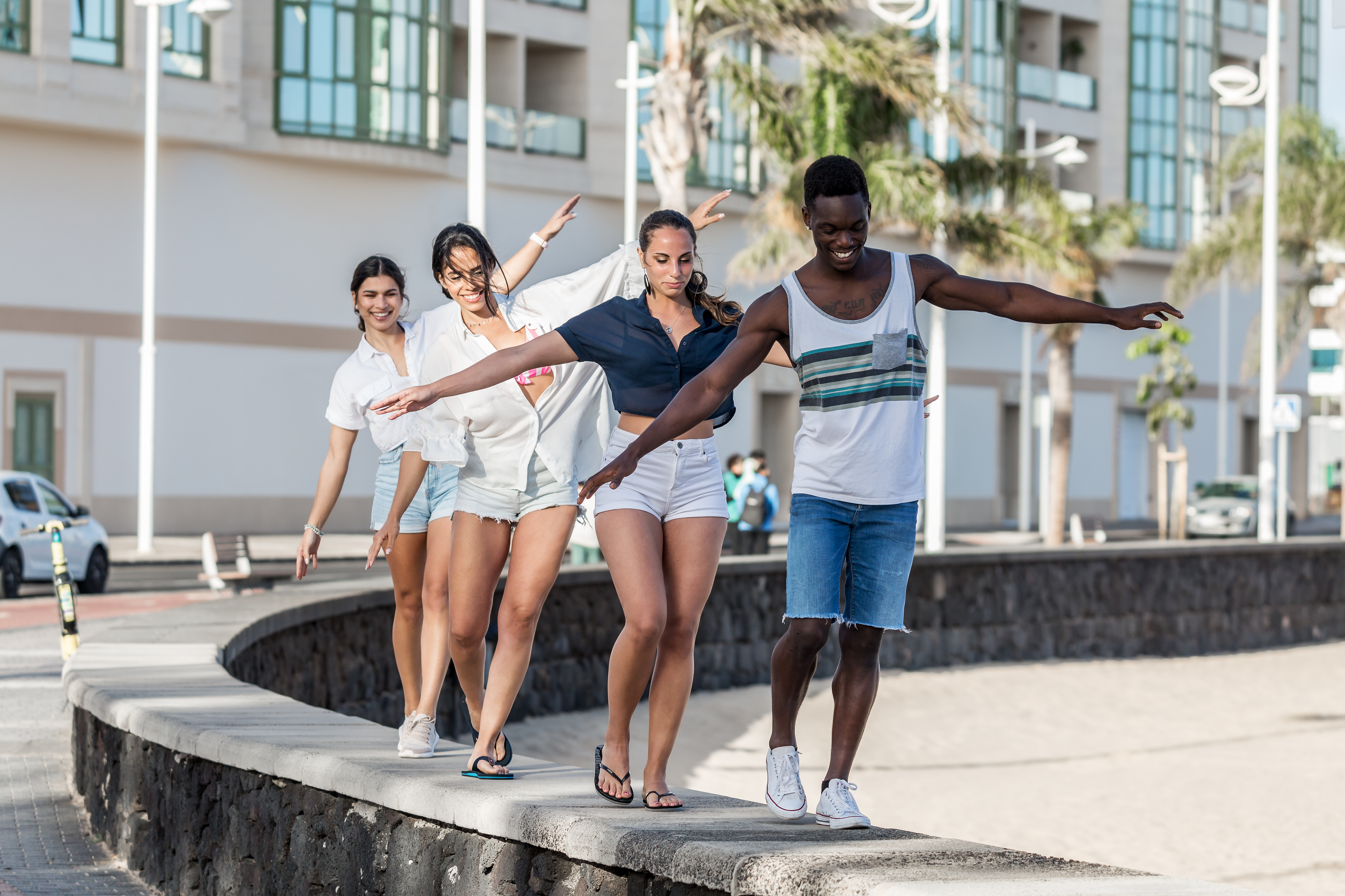 Four people walking on a concrete bench