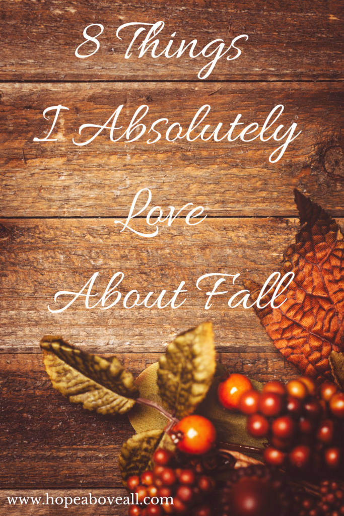 Picture of fall-colored leaves on wooden table and the title of the pin: 8 Things I Absolutely Love About Fall in white.