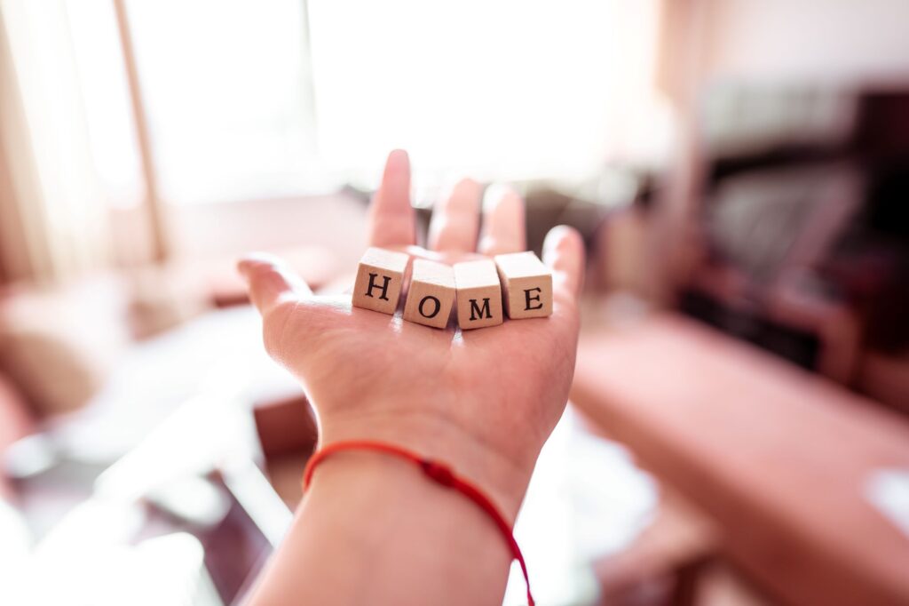 Hand holding wooden blocks spelling HOME
