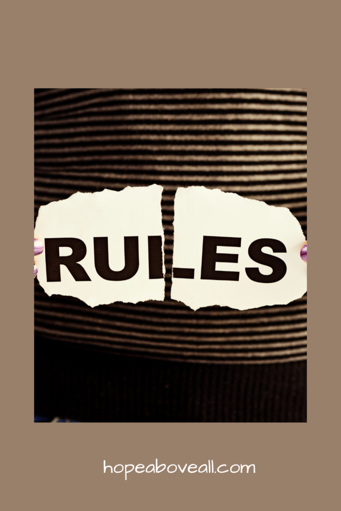 The word RULES written on a board is being broken in half to symbolize breaking the rules.