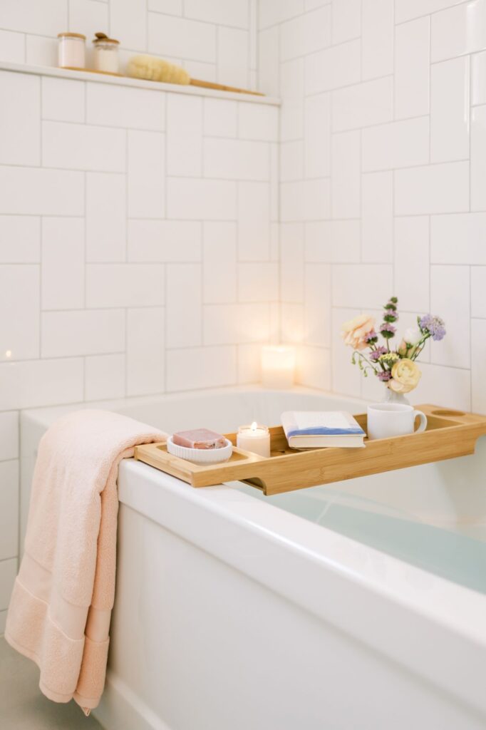 Self-care image of book and candle over a full bathtub