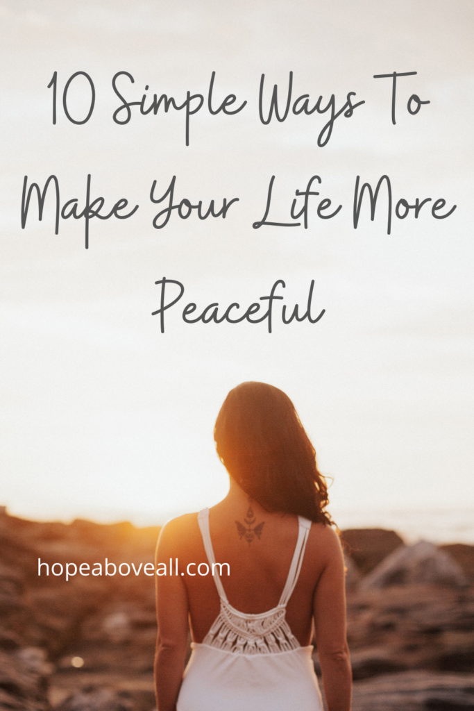 Pin with image of the back of a woman looking into the sunset.  The title: 10 Simple Ways To Make Your Life More Peaceful, is at the top.