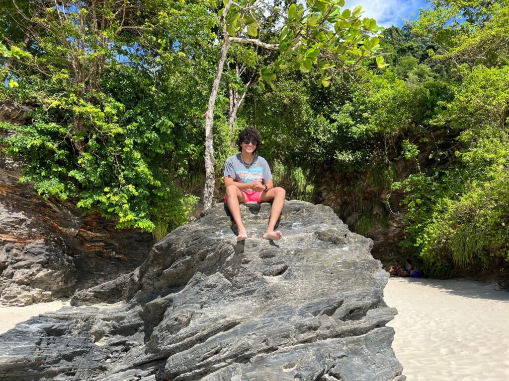 Picture of my son sitting on a large rock  at Las Cuevas Beach.
