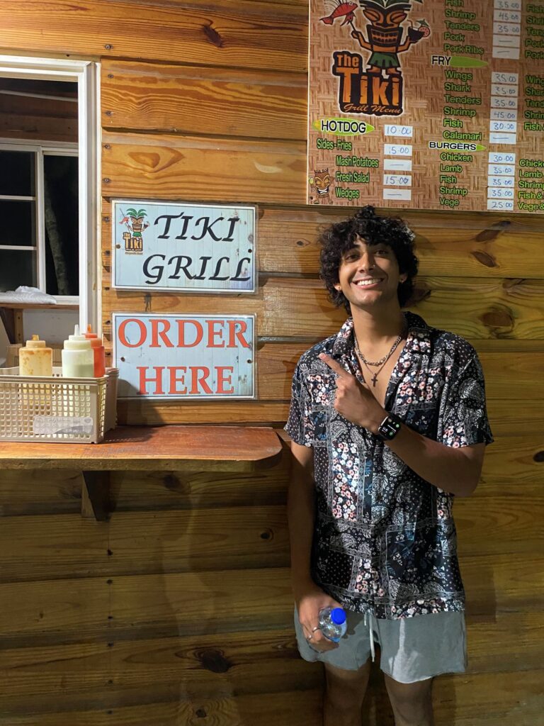 My son, Tikki pointing to the Tiki Grill sign.