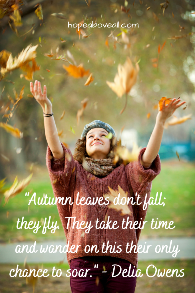 Woman catching falling leaves in Fall.