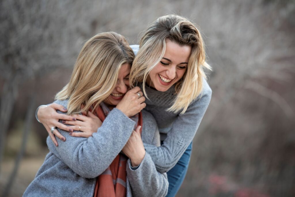 woman hugging another woman from behind