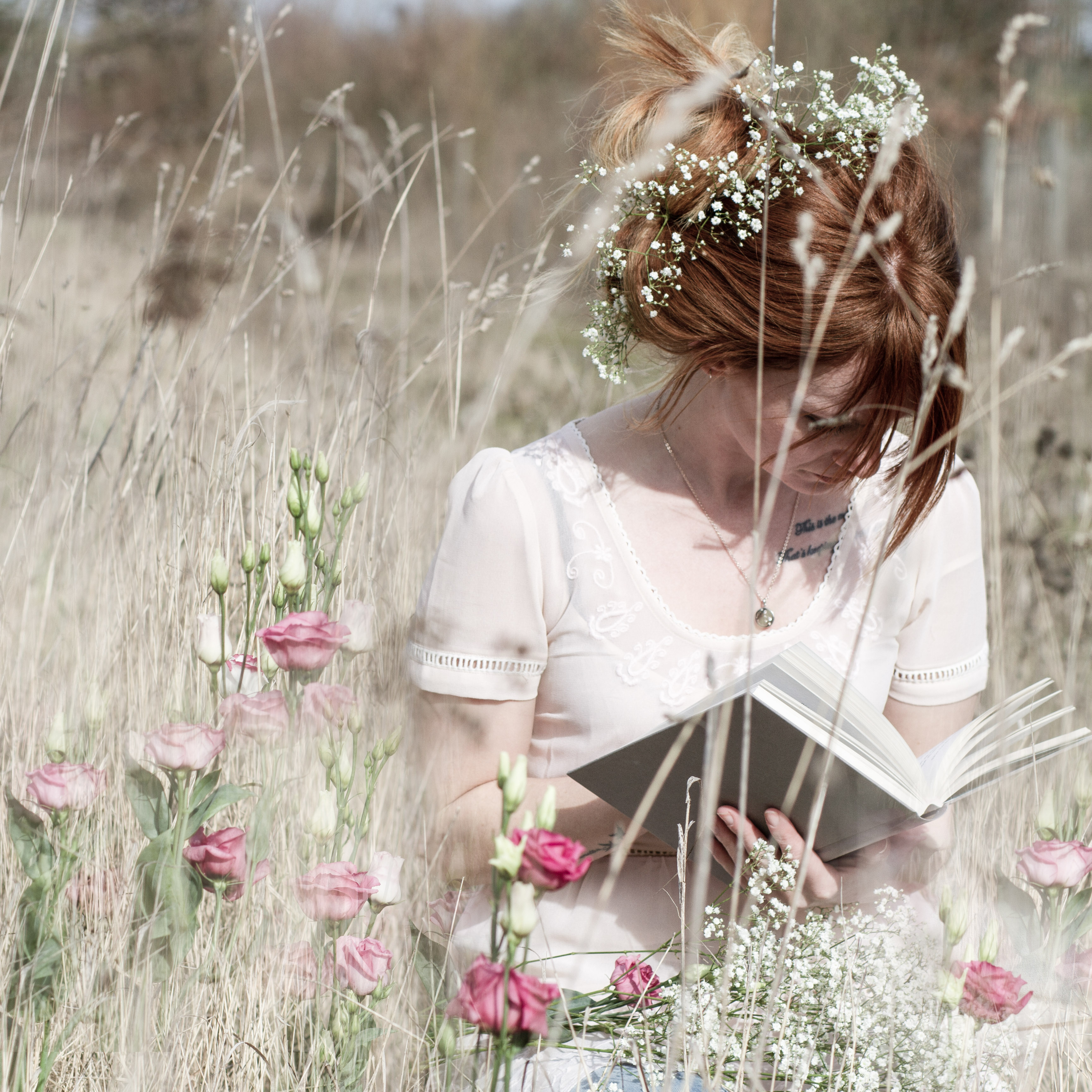 Woman journaling beside pink flowers