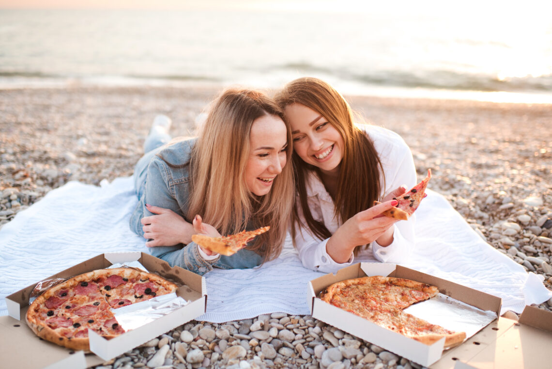 Two friends eating pizza