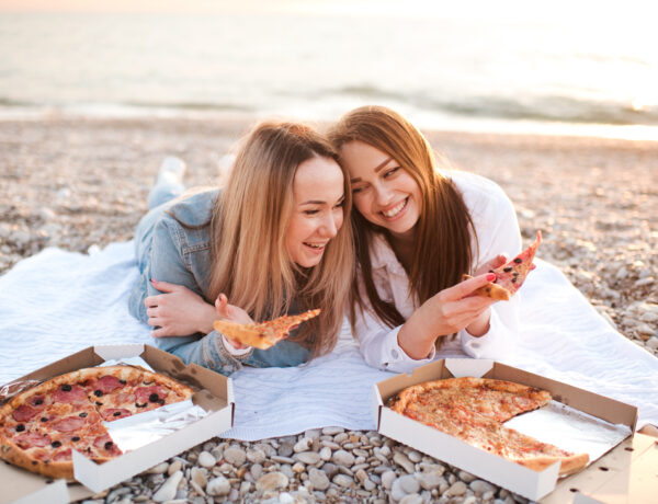 Two friends eating pizza