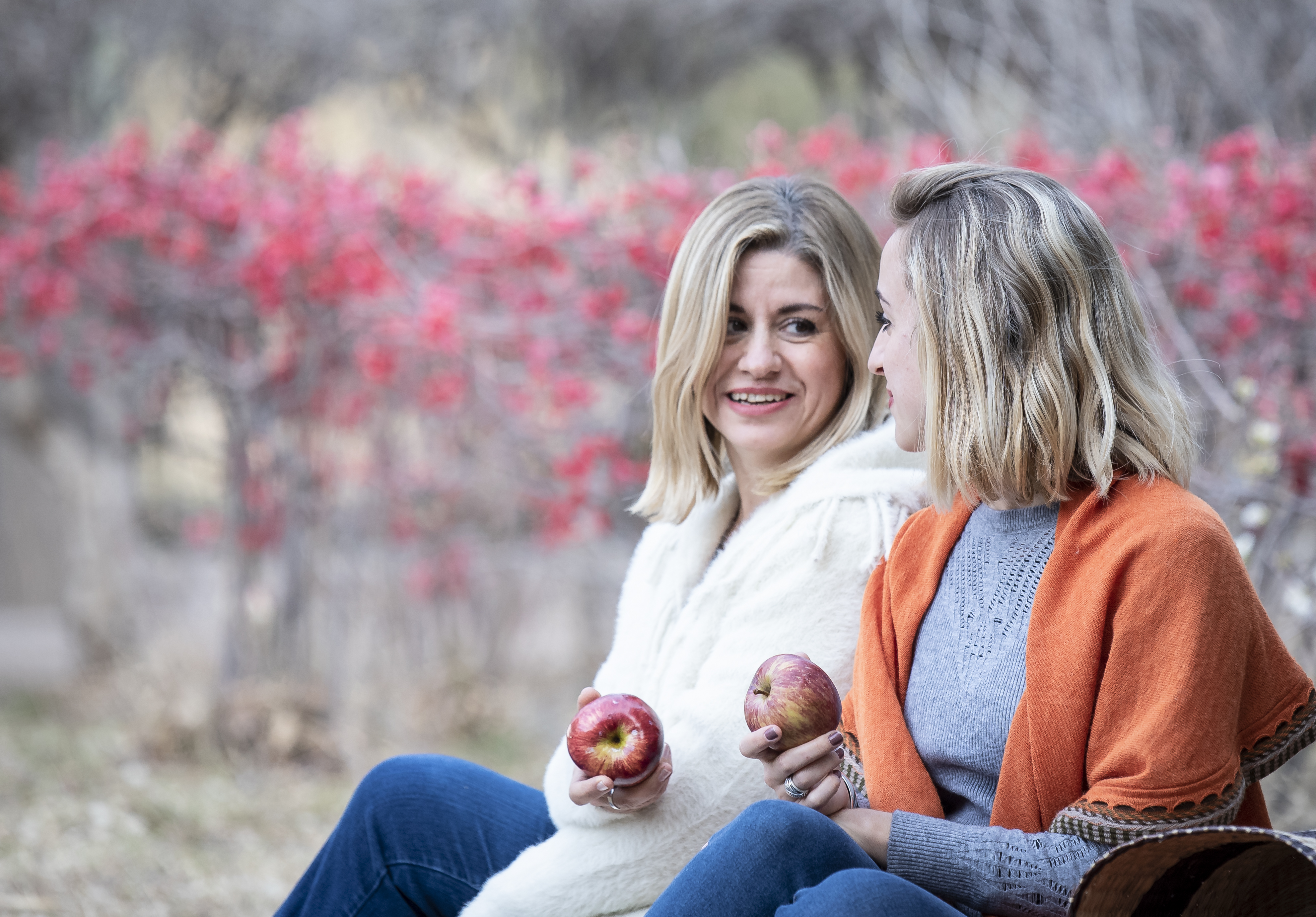 Mother and daughter holding apples outdoor