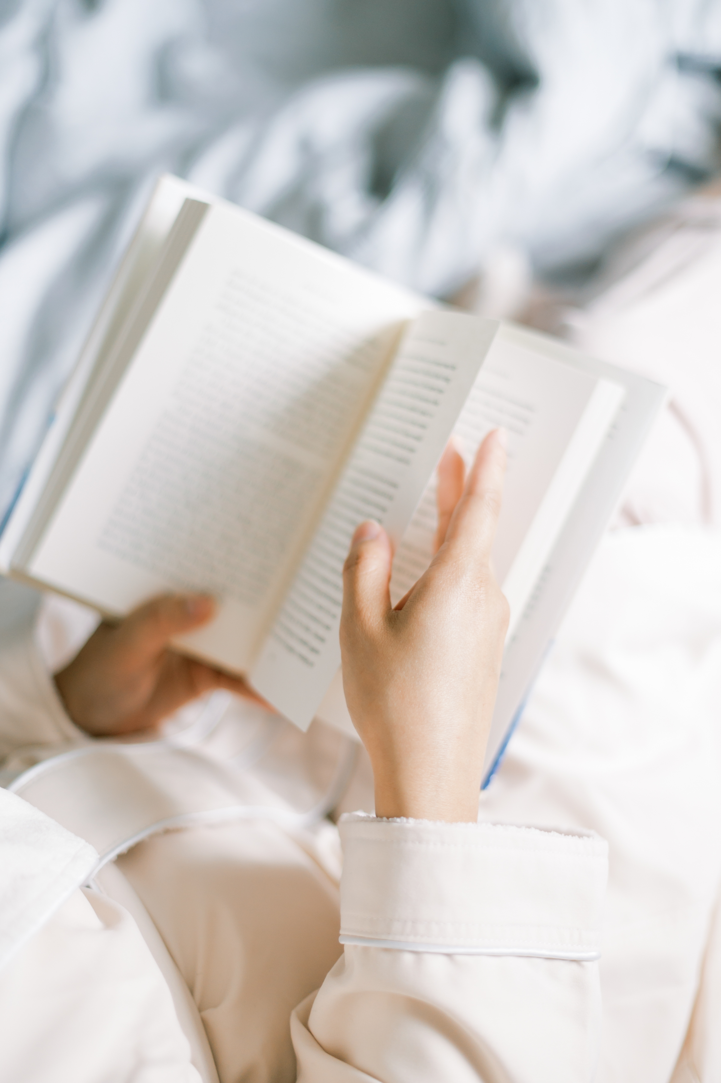 Woman reading a book while lying in bed