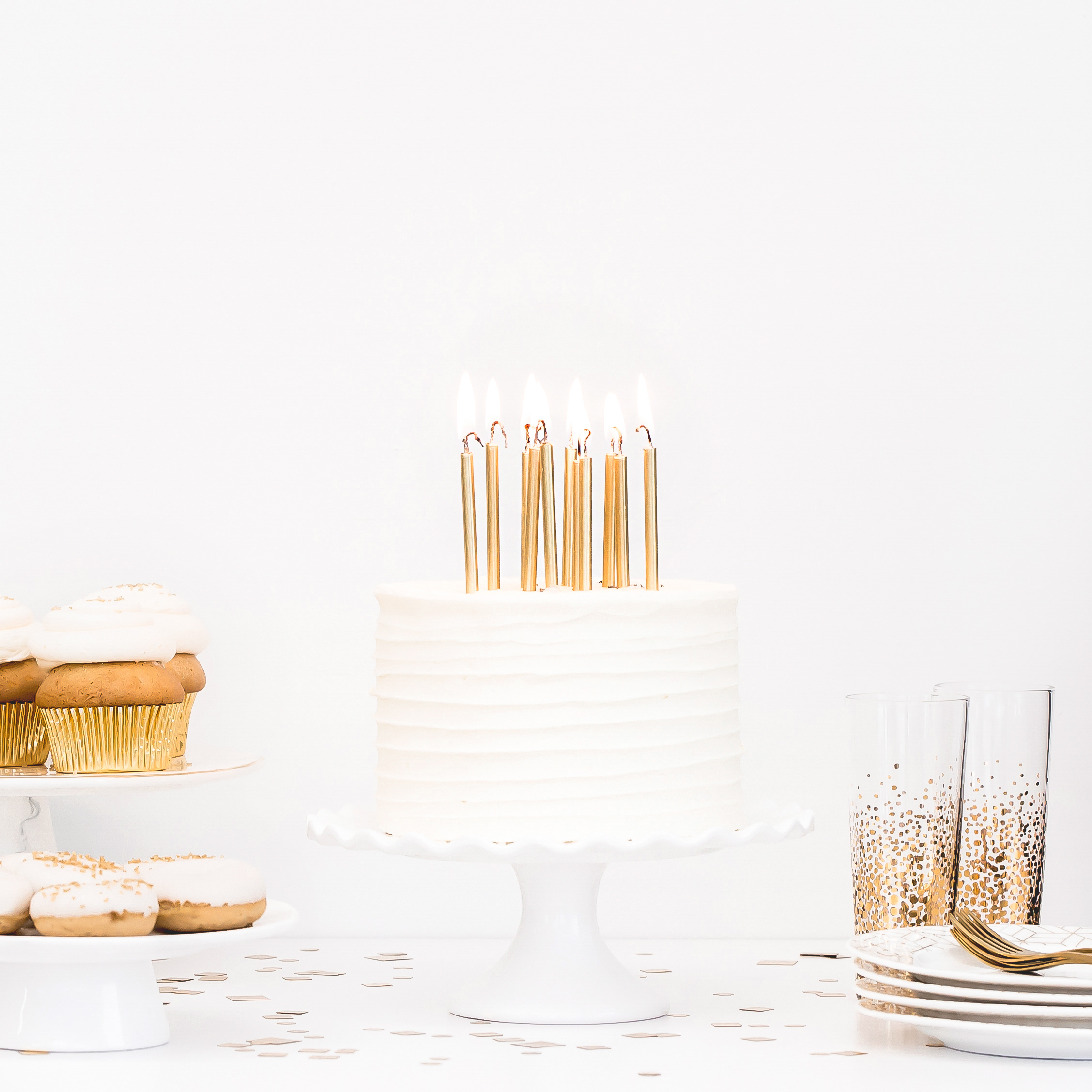 Table set with birthday cake, cupcakes, and drinks